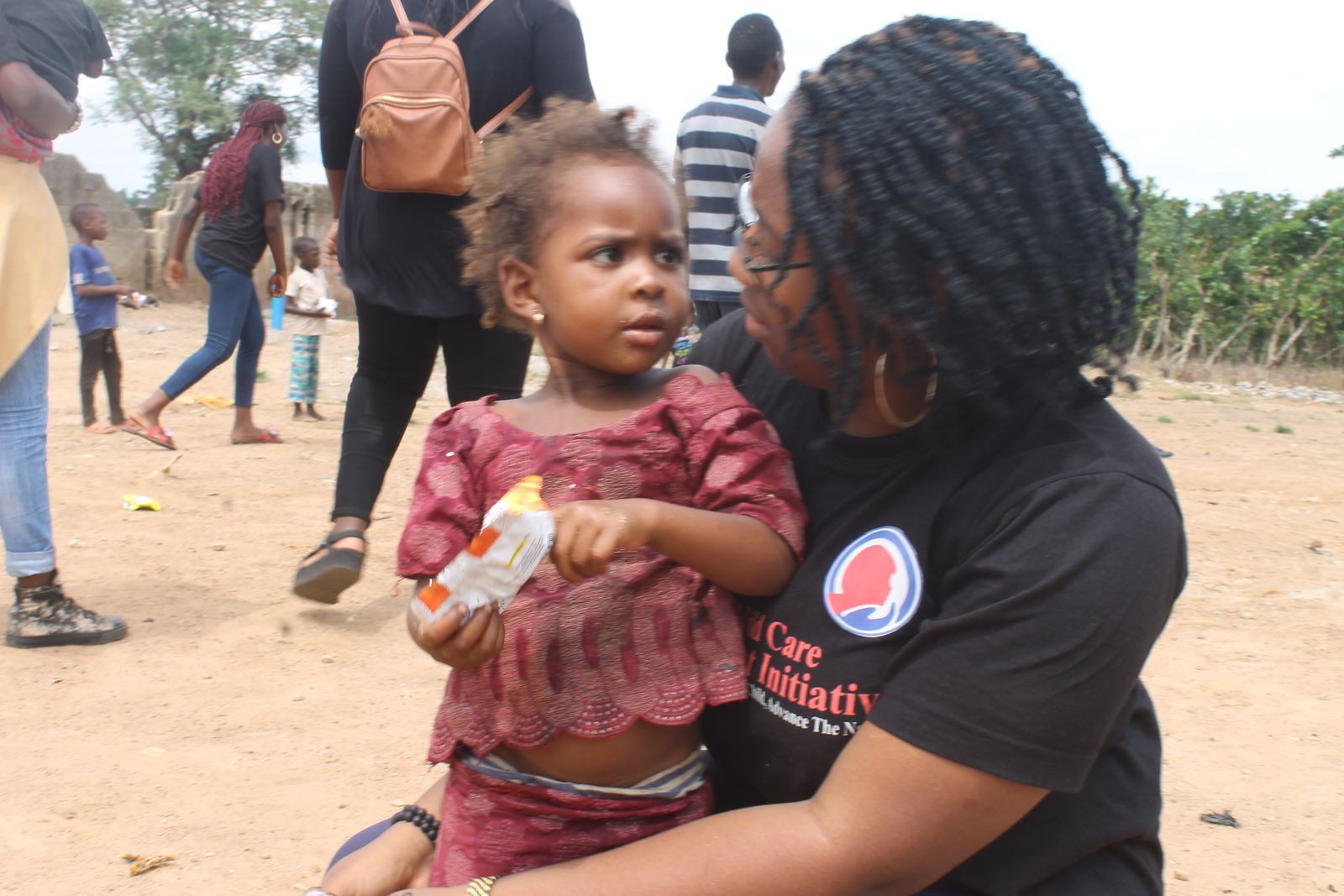 A GCCAI volunteer with a young girl during a community outreach